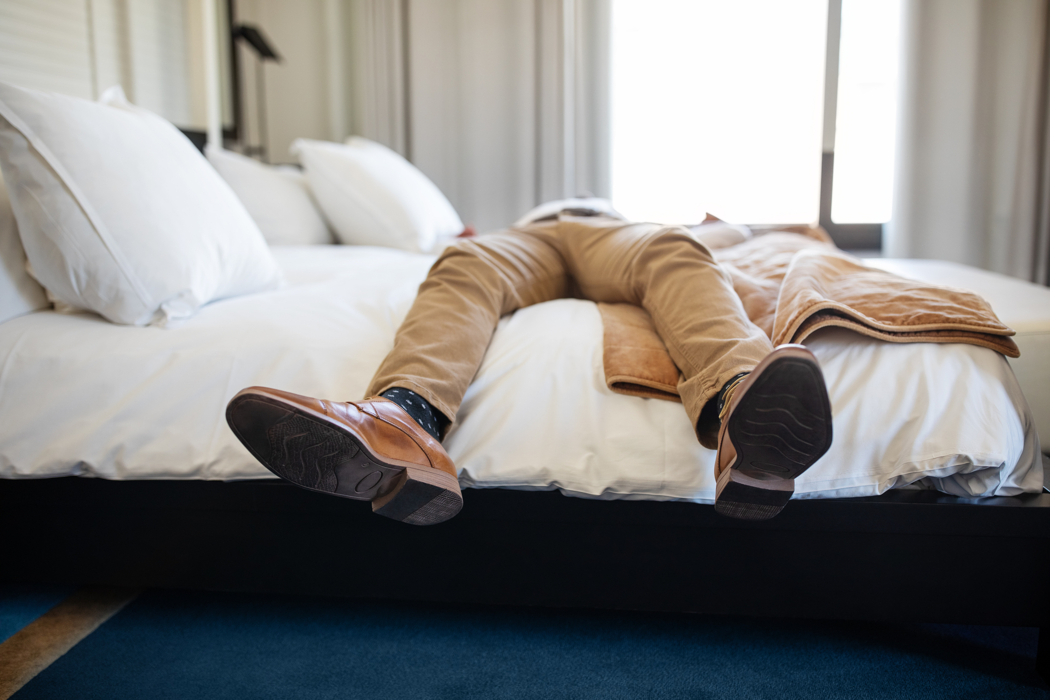 A man in formal attire hanging off of a mattress